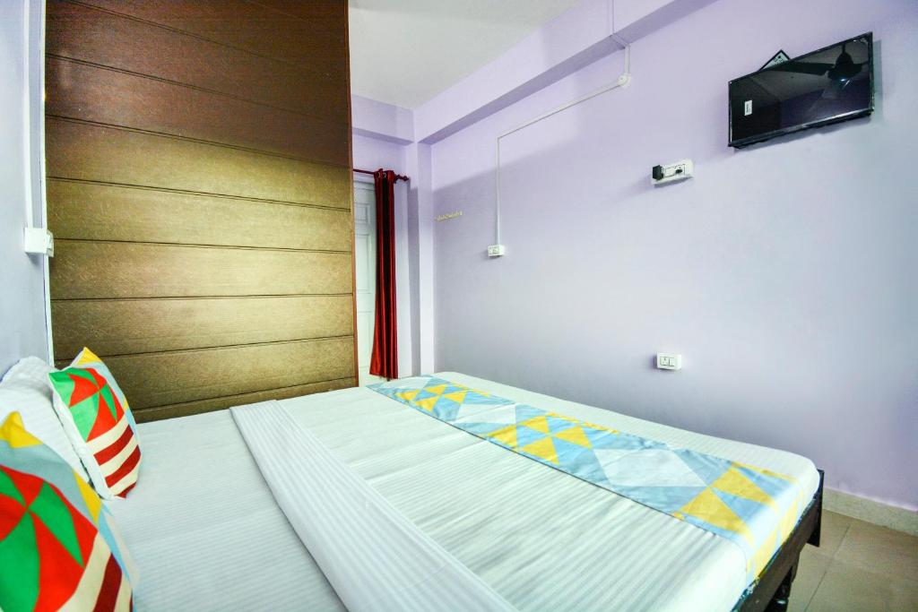 1 dormitorio con 1 cama y TV en la pared en Flagship The Alpine Homes en Solan