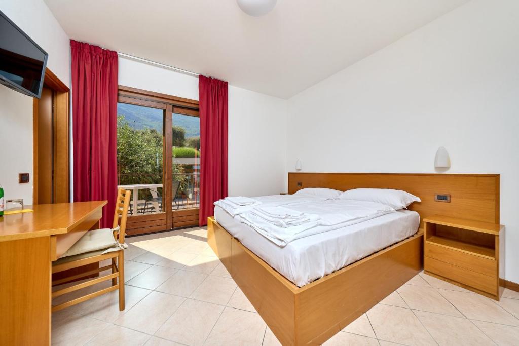 Schlafzimmer mit einem Bett, einem Schreibtisch und einem Fenster in der Unterkunft Locanda Bellavista food&rooms in Malcesine