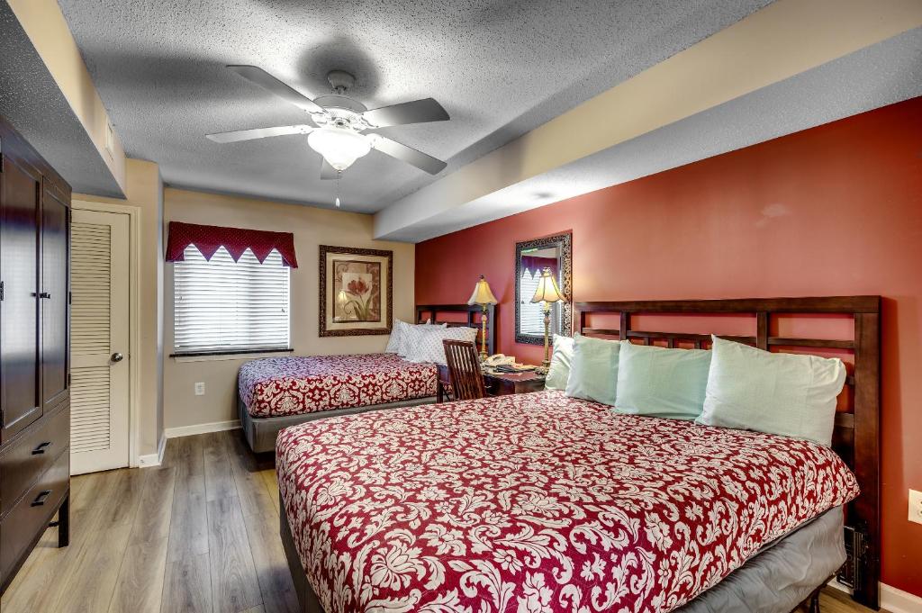 Un dormitorio con dos camas y un ventilador de techo. en Lovely Studio - Yacht Club, en Myrtle Beach