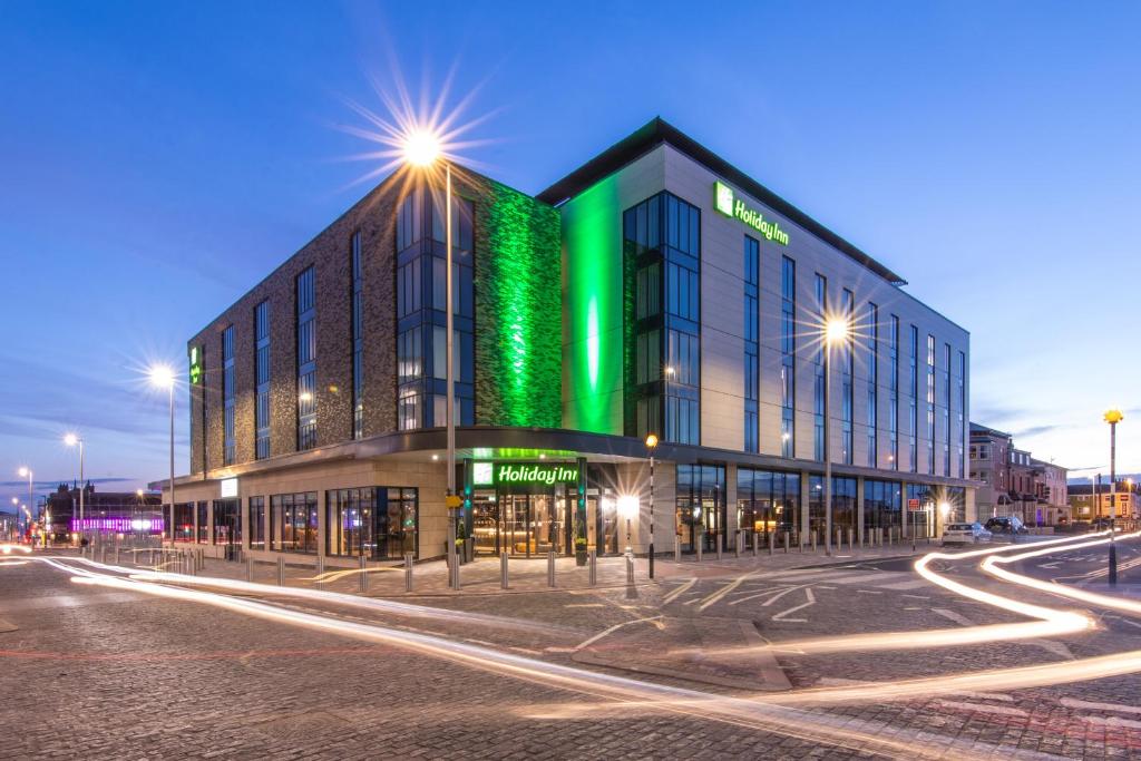 Un bâtiment avec des lumières vertes sur son côté dans l'établissement Holiday Inn Blackpool, an IHG Hotel, à Blackpool