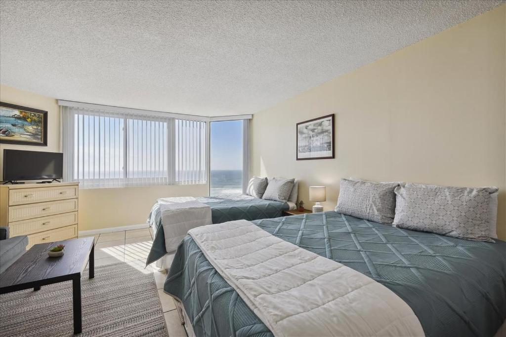 Un dormitorio con dos camas y una gran ventana. en 721 Top Of The Gulf, en Panama City Beach