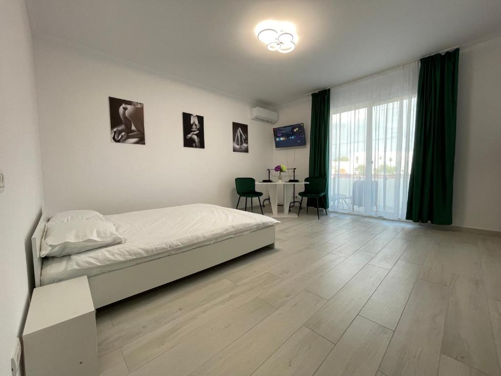 1 dormitorio con 1 cama y 1 mesa con sillas en Apartament R en Giroc