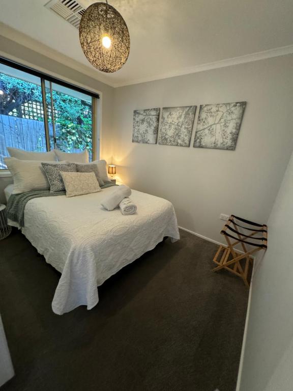 a bedroom with a bed and a large window at Belle in Bowral in Bowral