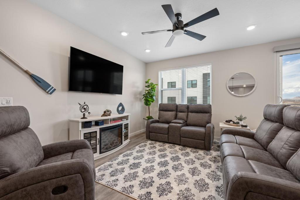 een woonkamer met twee banken en een flatscreen-tv bij Paddle Away condo in St. George