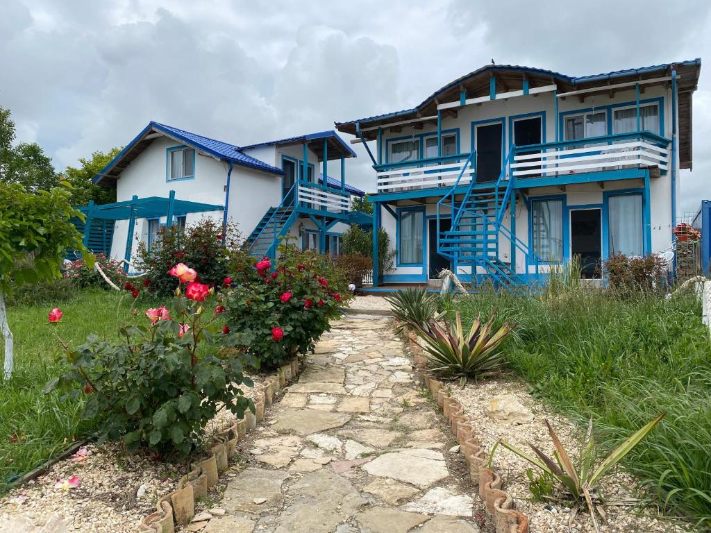 a blue and white house with flowers in front of it at Complex Turistic Răsărit Corbu in Corbu