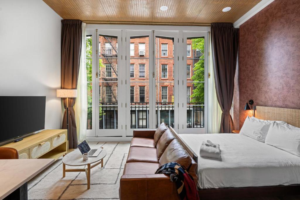 a hotel room with a bed and a large window at Sosuite at The Loxley - Old City in Philadelphia