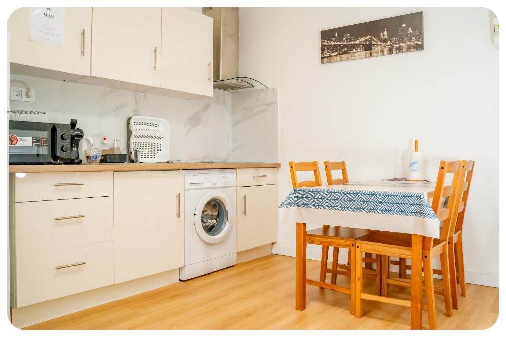 a kitchen with a table and chairs and a washing machine at 2 pièces entre Paris et Disney in Villiers-sur-Marne