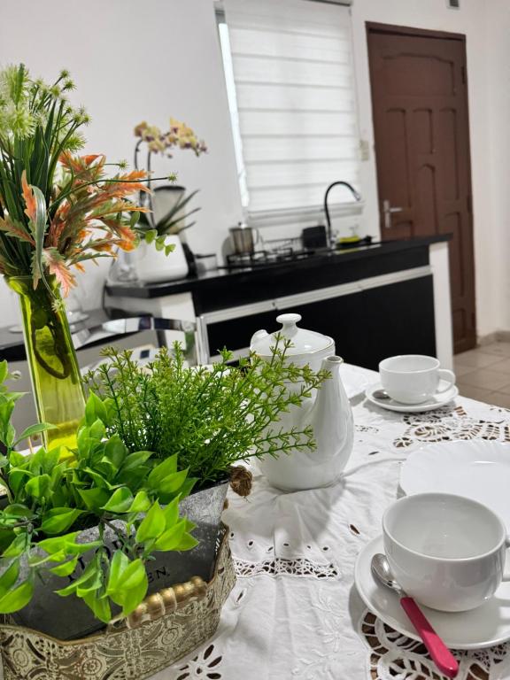 una mesa con platos y cuencos y flores en ella en Acogedor independiente-Casa JH A en Santa Cruz de la Sierra