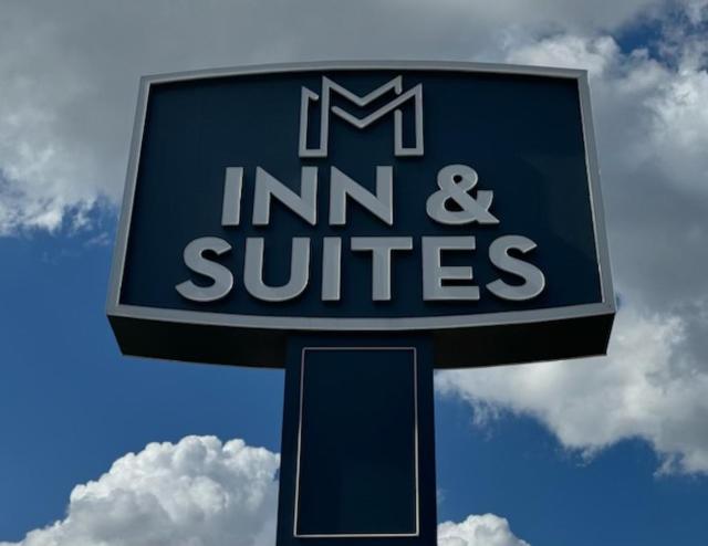 a sign for an inn and suites on a pole at M&M Inn and Suites in Fort Worth