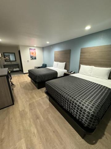una camera d'albergo con due letti e una televisione di M&M Inn and Suites a Fort Worth