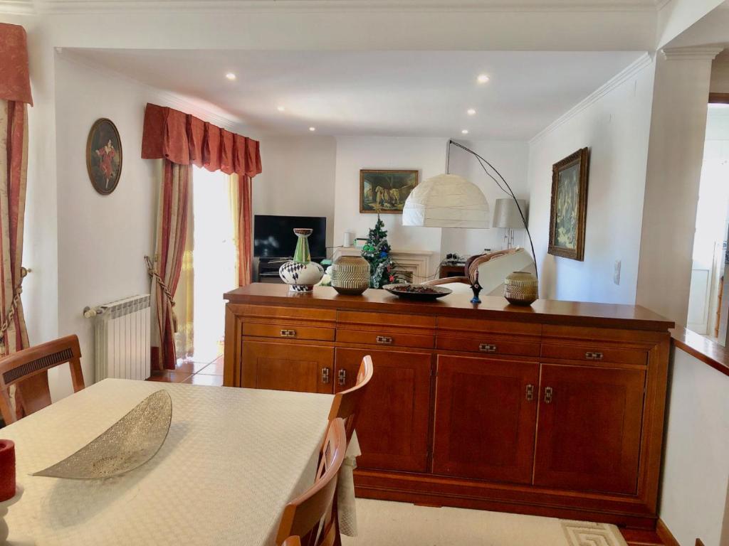 a kitchen with a table and a large wooden cabinet at Grace Villa in Aldeia de Juso