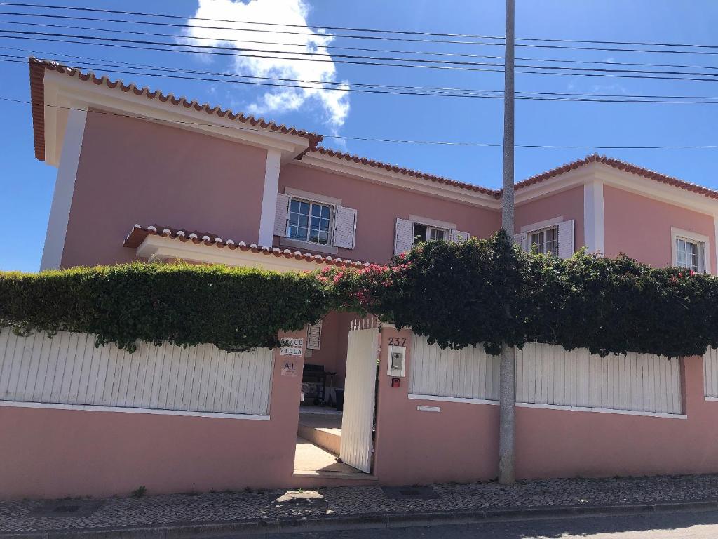 różowy dom z drzewami przed nim w obiekcie Grace Villa w mieście Aldeia de Juso