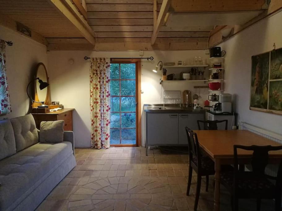 Skåne-TranåsにあるCharming cottage in a beautiful landscapeのリビングルーム(ソファ、テーブル付)、キッチンが備わります。