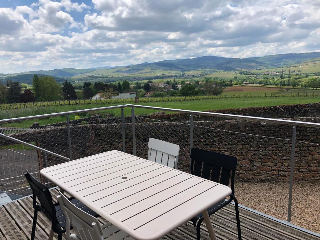 a white table and chairs on a balcony with a view at appartement contemporain dans une authentique demeure viticole in Charnay-lès-Mâcon