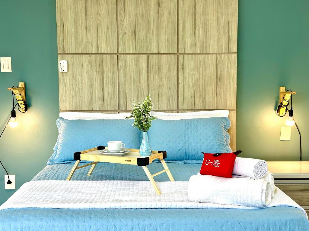 a bedroom with a blue bed with a table on it at (107) Beach Mar e Sol - Perto da Praia in Pimenta