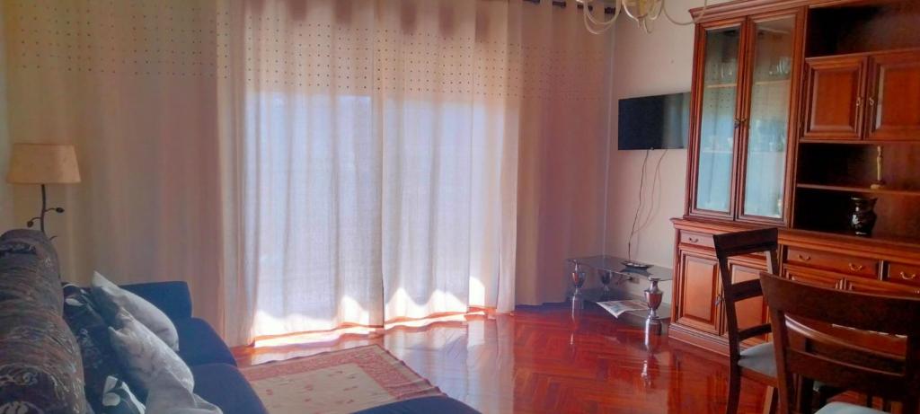 - un salon avec une grande fenêtre et des rideaux dans l'établissement HR Liberdade, à Sarria