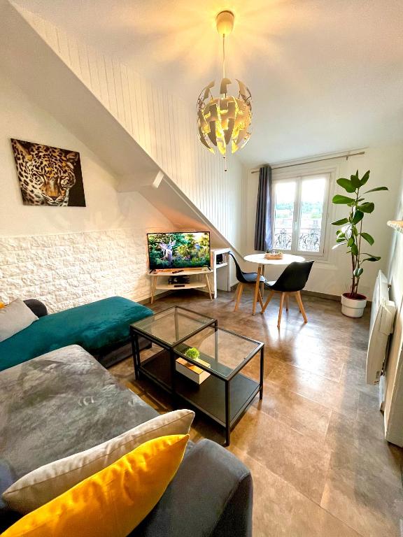 un salon avec un canapé et une table dans l'établissement Superbe Appart entier au pied de la Gare RER, à 15 min de Paris & Orly, à Juvisy-sur-Orge