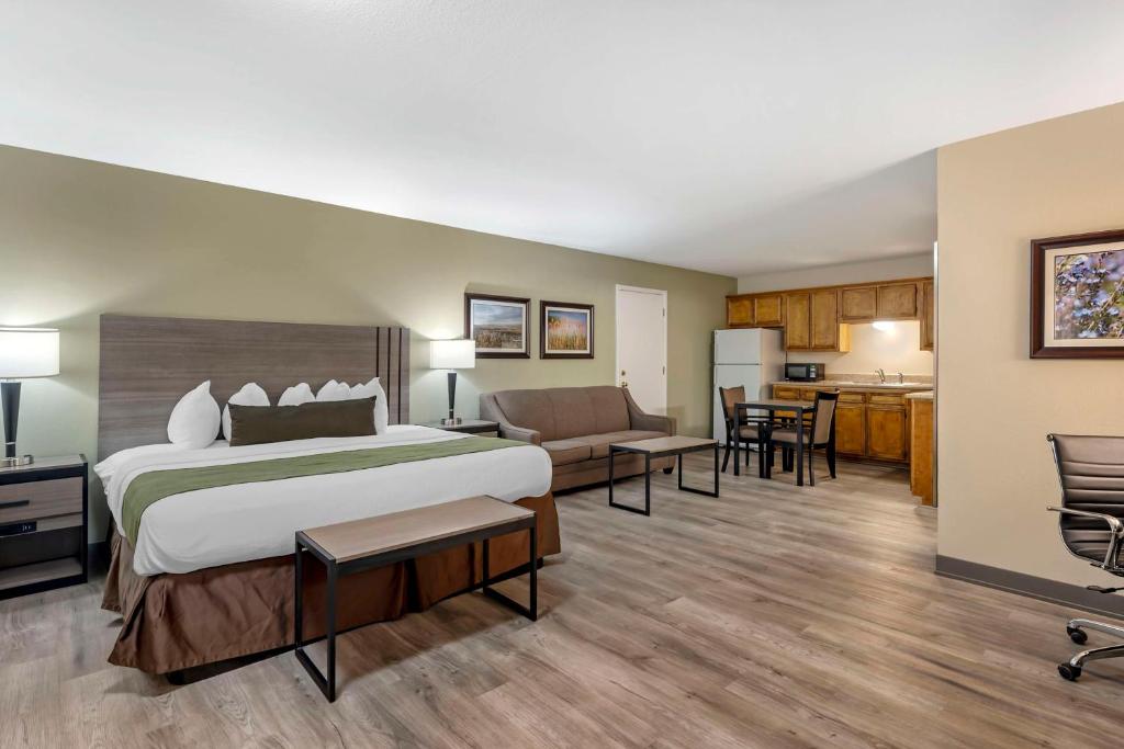 a hotel room with a large bed and a kitchen at Best Western Inn of Brenham in Brenham