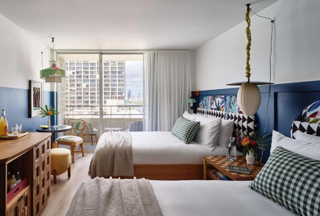 een hotelkamer met 2 bedden en een raam bij Wayfinder Waikiki in Honolulu