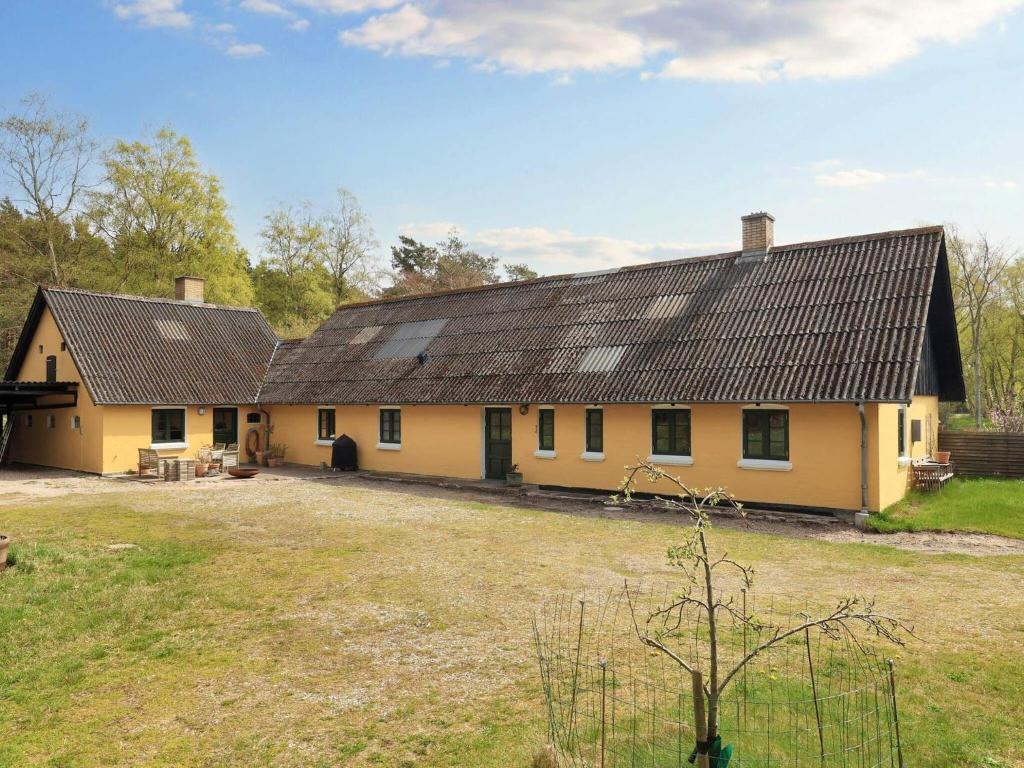 uma casa amarela com um telhado preto em Holiday home Læsø IV em Læsø