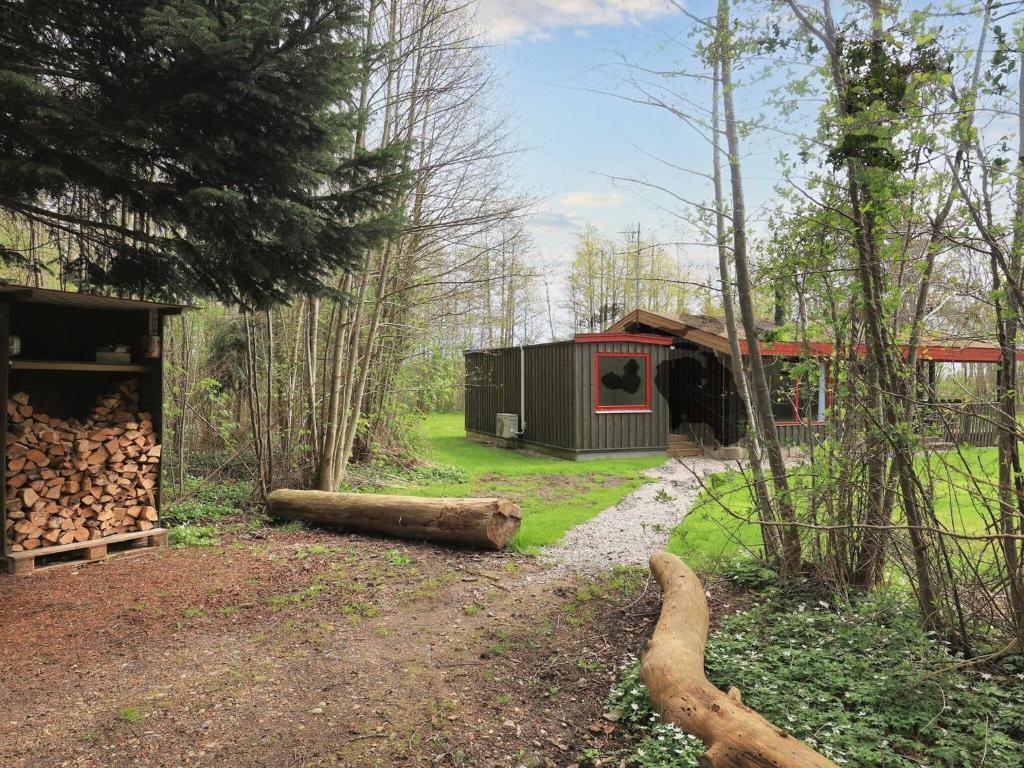 una cabaña en el bosque con un montón de troncos en Holiday home Læsø XXV en Læsø