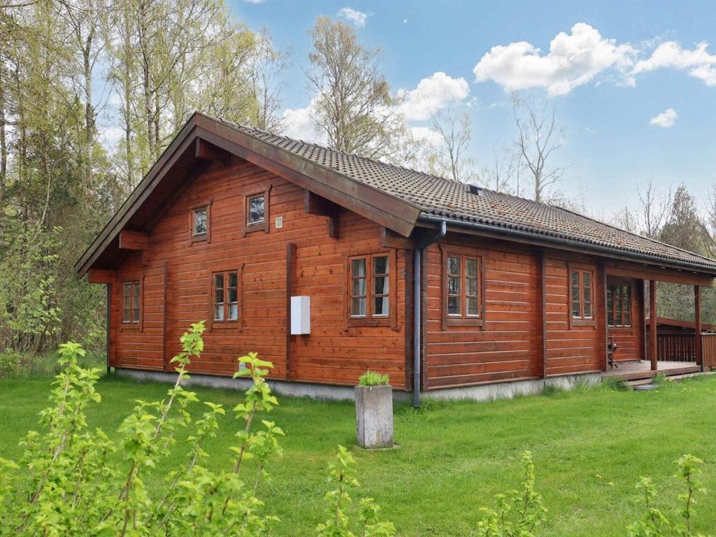 una casa de madera en un campo con patio en Holiday home Læsø XII, en Læsø