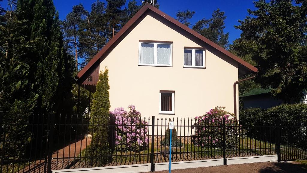 una casa blanca con una valla negra en Dom Wakacyjny, en Rowy