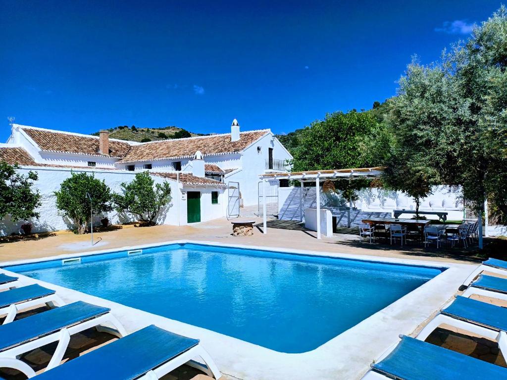 uma villa com uma piscina e espreguiçadeiras em Cortijo Alzamigaja em Archidona