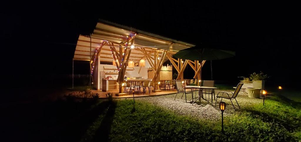 a house with a table and an umbrella at night at Ecohotel Alma in Calarcá