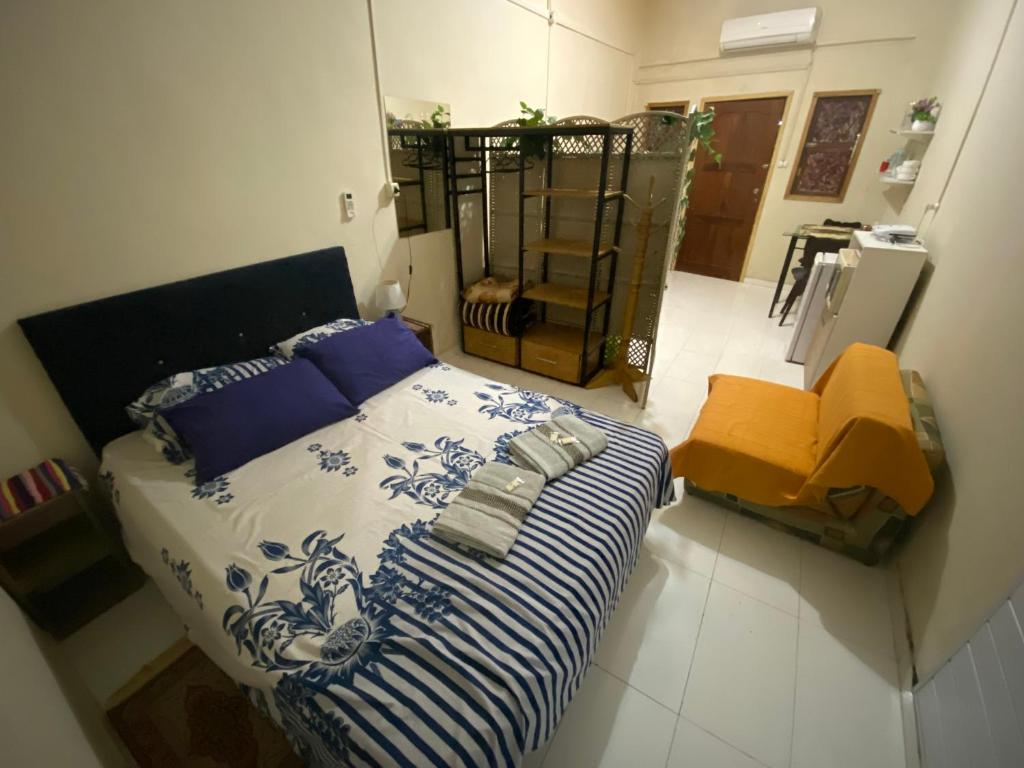 Schlafzimmer mit einem Bett mit blauer und weißer Bettwäsche in der Unterkunft Villa Morra House in Asunción