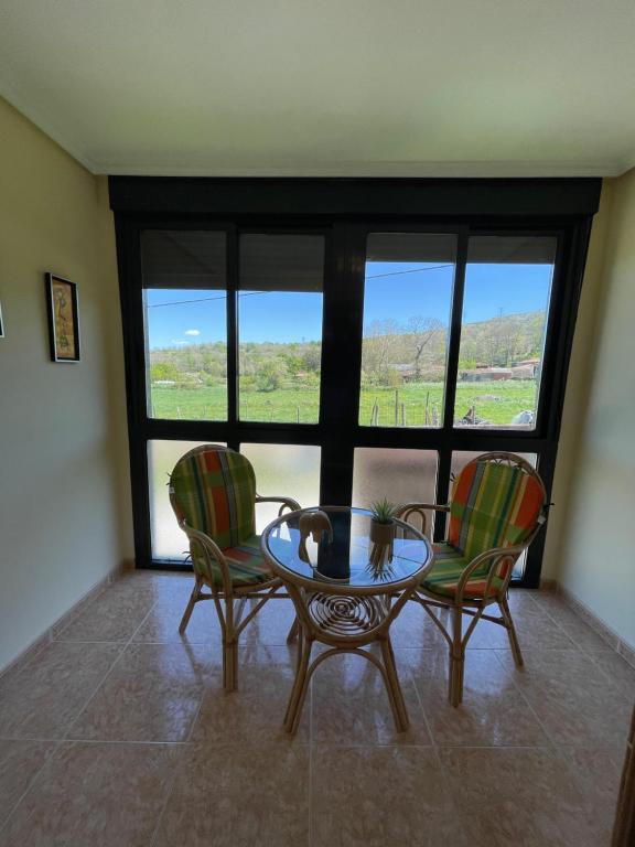 a room with a table and two chairs and a window at Casa rural Herminia in Ourense