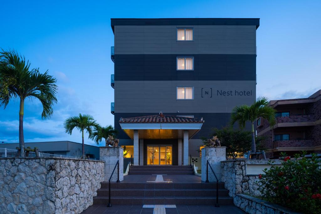 Un edificio negro con palmeras delante. en Nest Hotel Ishigaki Maesato Beach, en Ishigaki Island