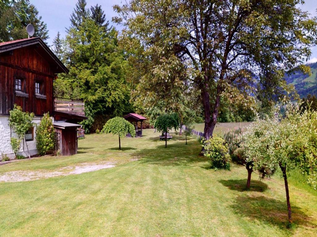 une cour avec une grange, des arbres et une maison dans l'établissement Alpin Hideaway L, à Wörgl