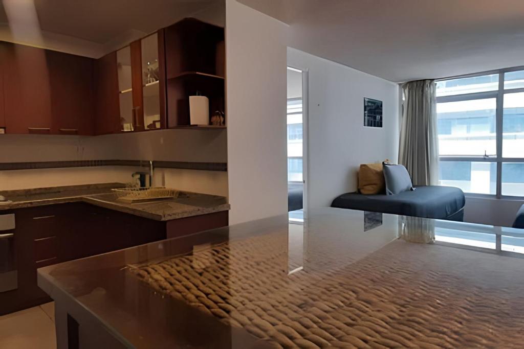 une cuisine avec un évier et un canapé dans une chambre dans l'établissement Apartamento Living Moneda (dp 302), à Santiago