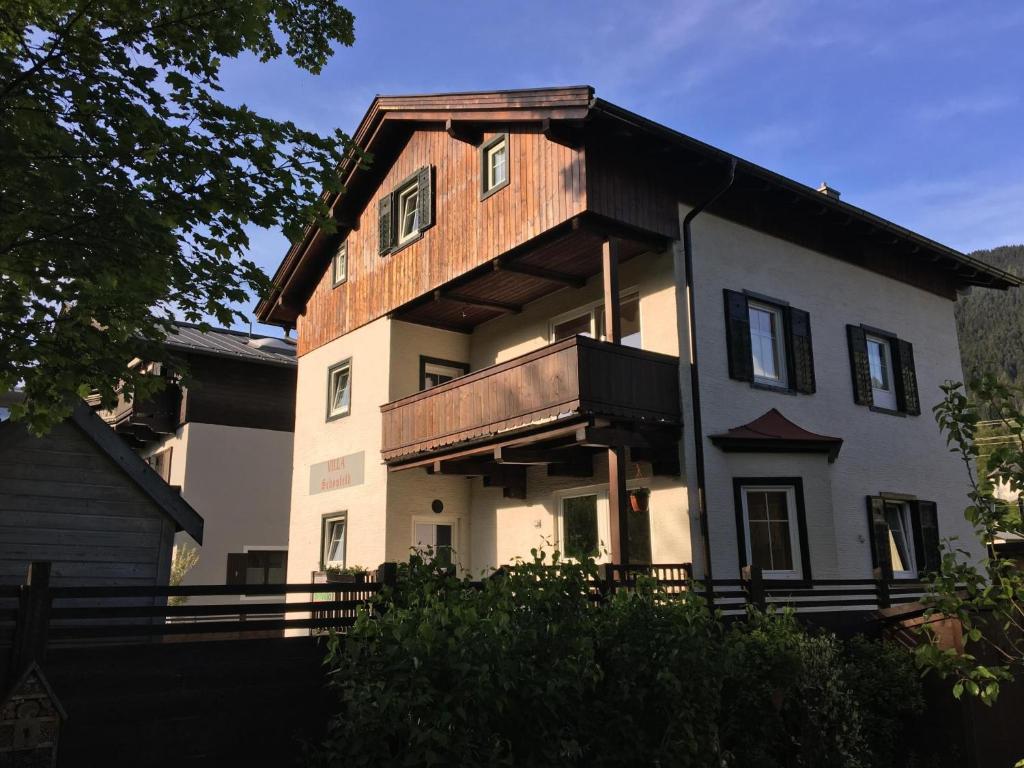 een groot wit huis met een houten dak bij Schönfeld I in Kitzbühel