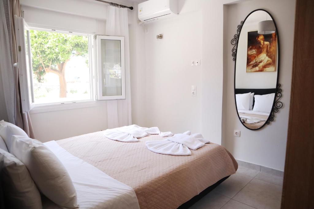 una camera da letto con un letto con uno specchio sul muro di Aegean Front Gem Stylish Home a Samos