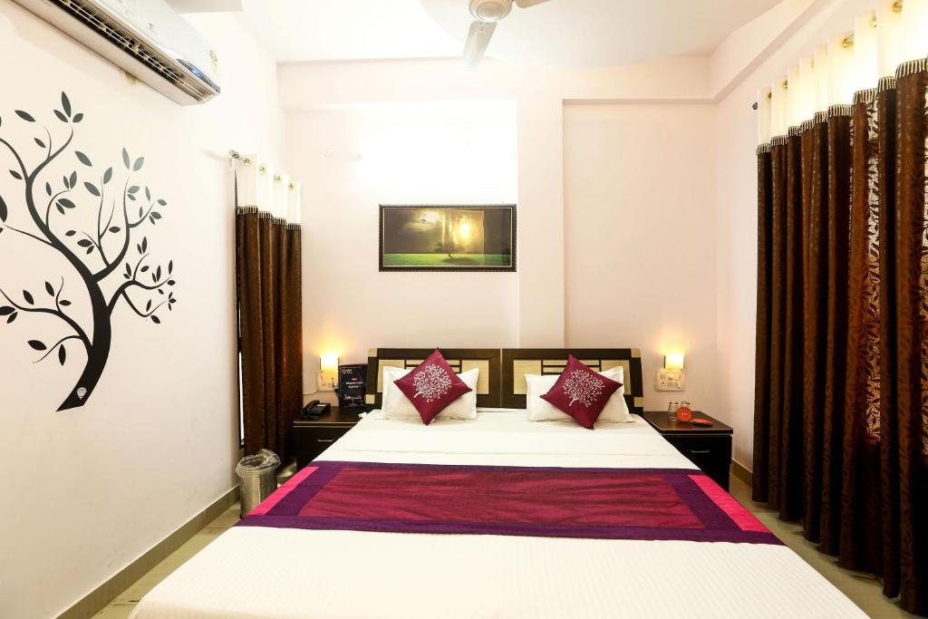 1 dormitorio con 1 cama grande con almohadas rojas en OYO Hotel Plaza Inn, en Bhopal