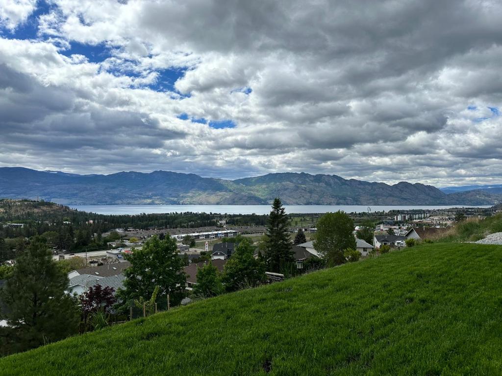 a green hill with a view of a town and a lake at Shannon Heights B&B in West Kelowna