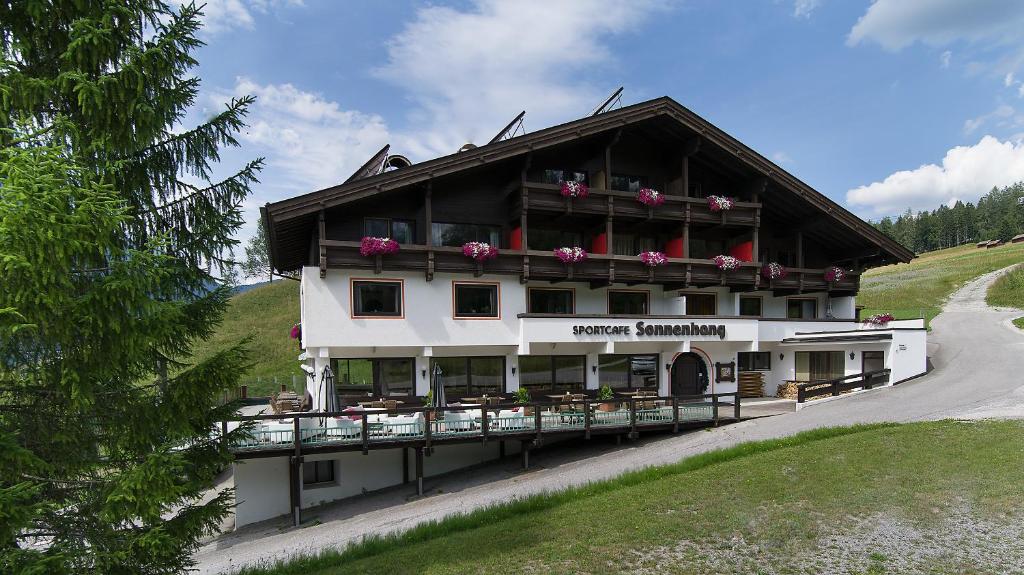 - un grand bâtiment avec des fleurs sur le balcon dans l'établissement Appartementhaus Sonnenhang, à Ehrwald