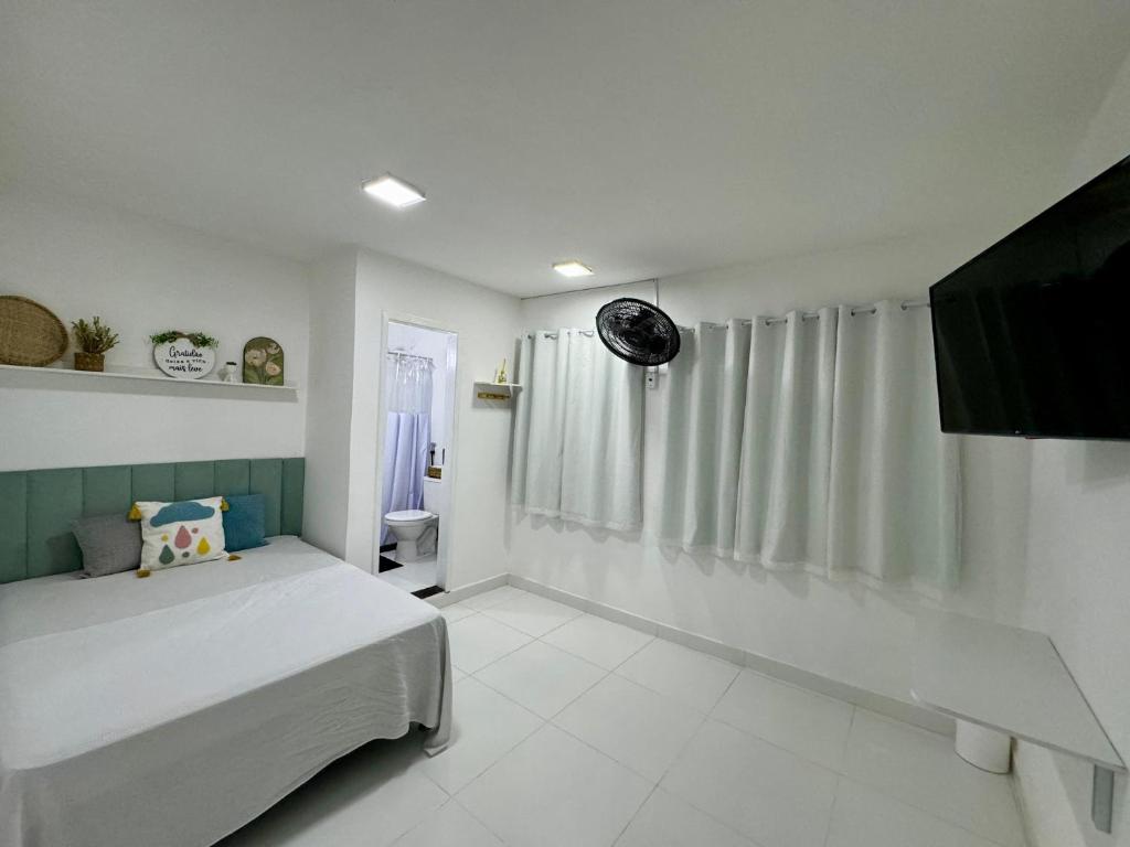 een slaapkamer met een bed en een toilet. bij Âncora Suítes Arraial do Cabo in Arraial do Cabo