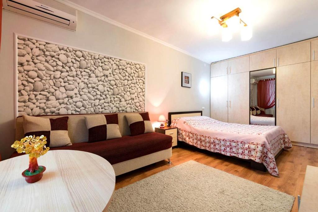 - un salon avec un canapé et un lit dans l'établissement Nadezhda Apartment on Abay Avenue 59, à Almaty