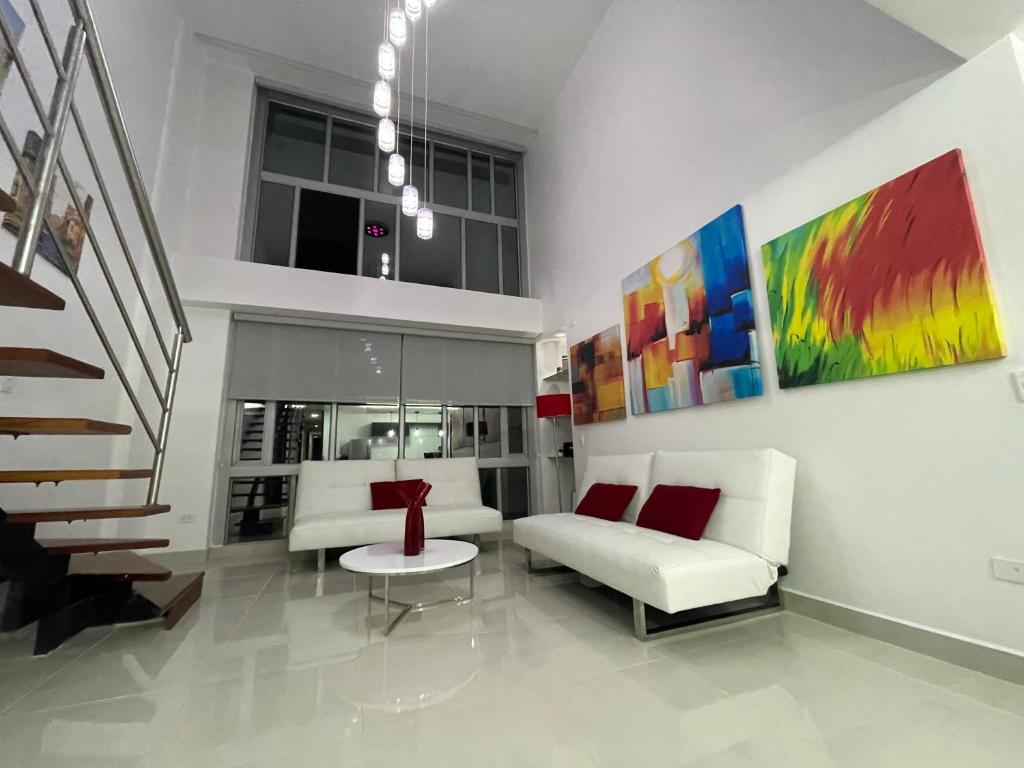 uma sala de estar com dois sofás brancos e uma escadaria em ItsaHome Apartments - Torre Aqua em Quito