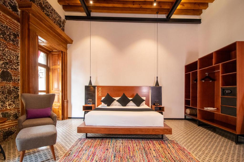 1 dormitorio con 1 cama y 1 silla en Casa de la Luz Hotel Boutique en Ciudad de México
