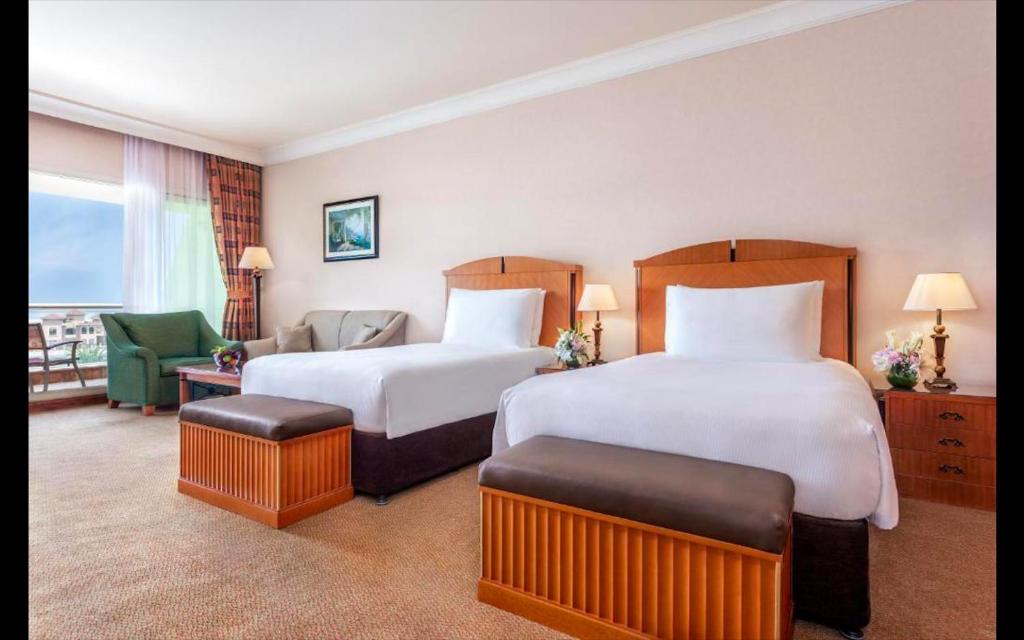 Pokój hotelowy z 2 łóżkami i krzesłem w obiekcie Al Raha Beach Hotel - Gulf View Room DBL - UAE w Abu Zabi