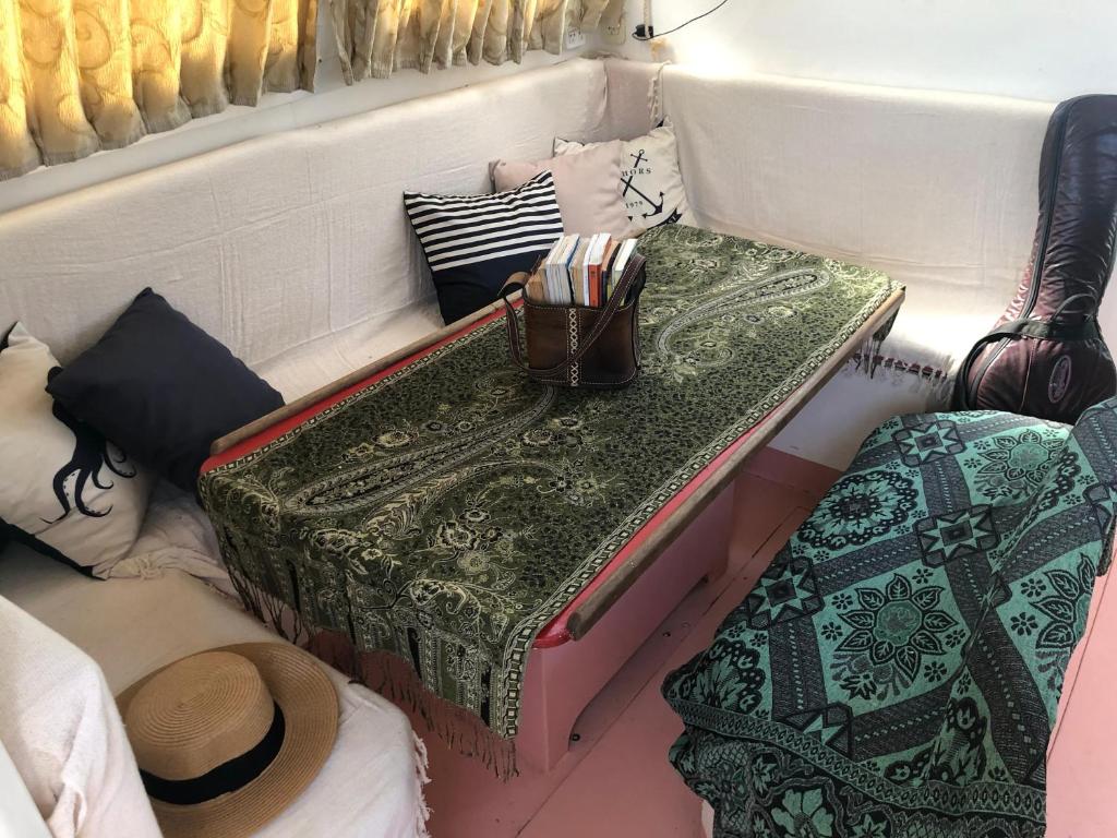 帕拉蒂的住宿－Velero Maverick hospedagem flutuante Centro Historico，客房配有桌子和带枕头的床。