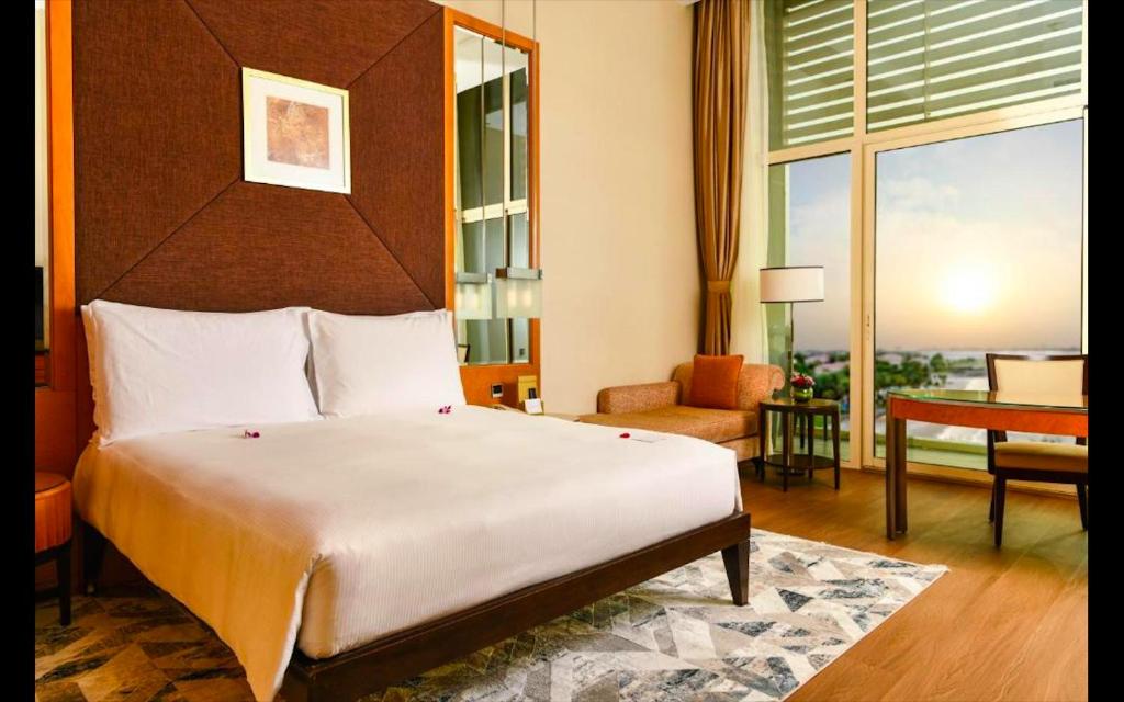 アブダビにあるAl Raha Beach Hotel - Deluxe Gulf Room SGL - UAEのベッドルーム(大型ベッド1台付)、リビングルームが備わります。