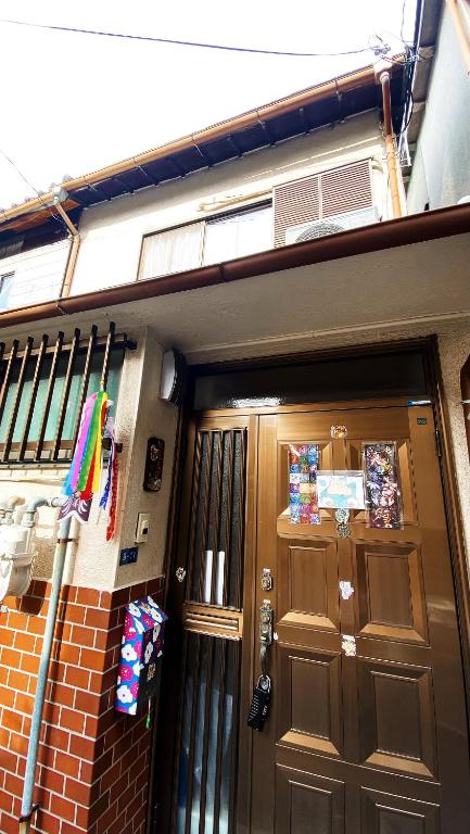 a house with a door and a brick wall at Pokémon Sleep 宝可梦的家 in Osaka