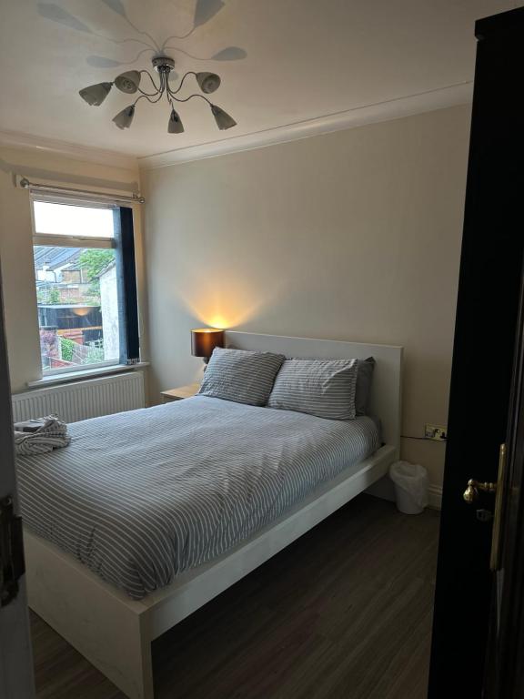 Un dormitorio con una cama con ventilador de techo. en Leavesden Residence - Central - Cosy - Harry Potter, en Leavesden Green