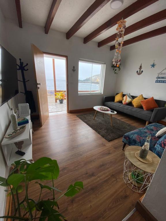 een woonkamer met een bank en een tafel bij BAHÍA SUR HOUSE - San Bartolo in San Bartolo