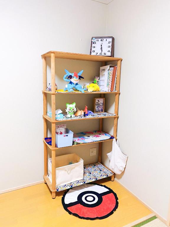 a book shelf with toys on it in a room at Pokémon Sleep 宝可梦的家 in Osaka